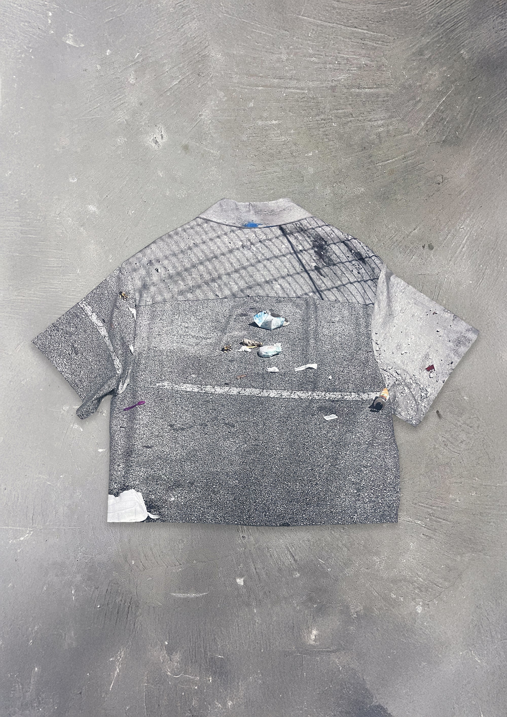 Gray textured shirt on a gray concrete surface