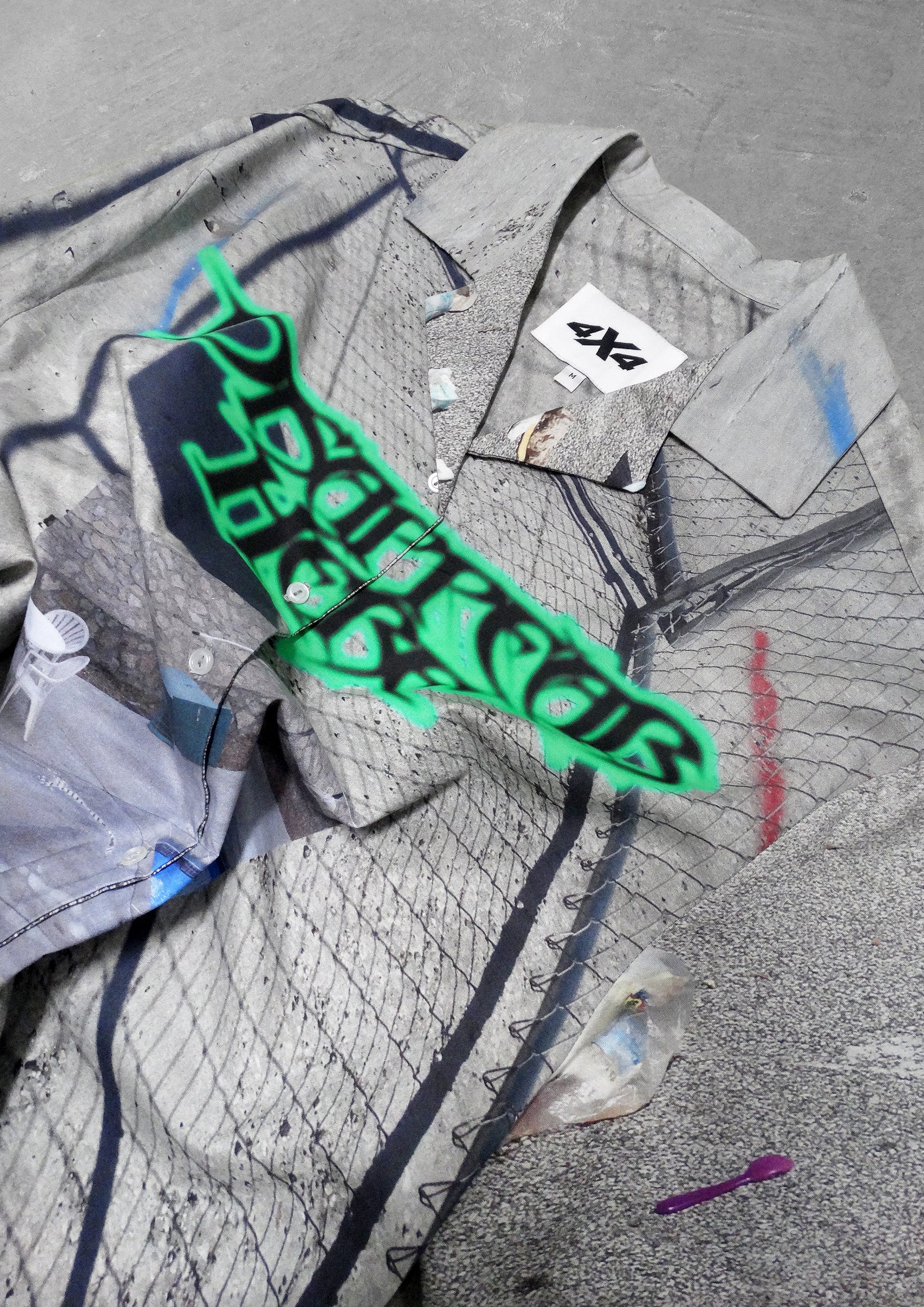 Gray jacket with green graffiti-style text on a textured surface
