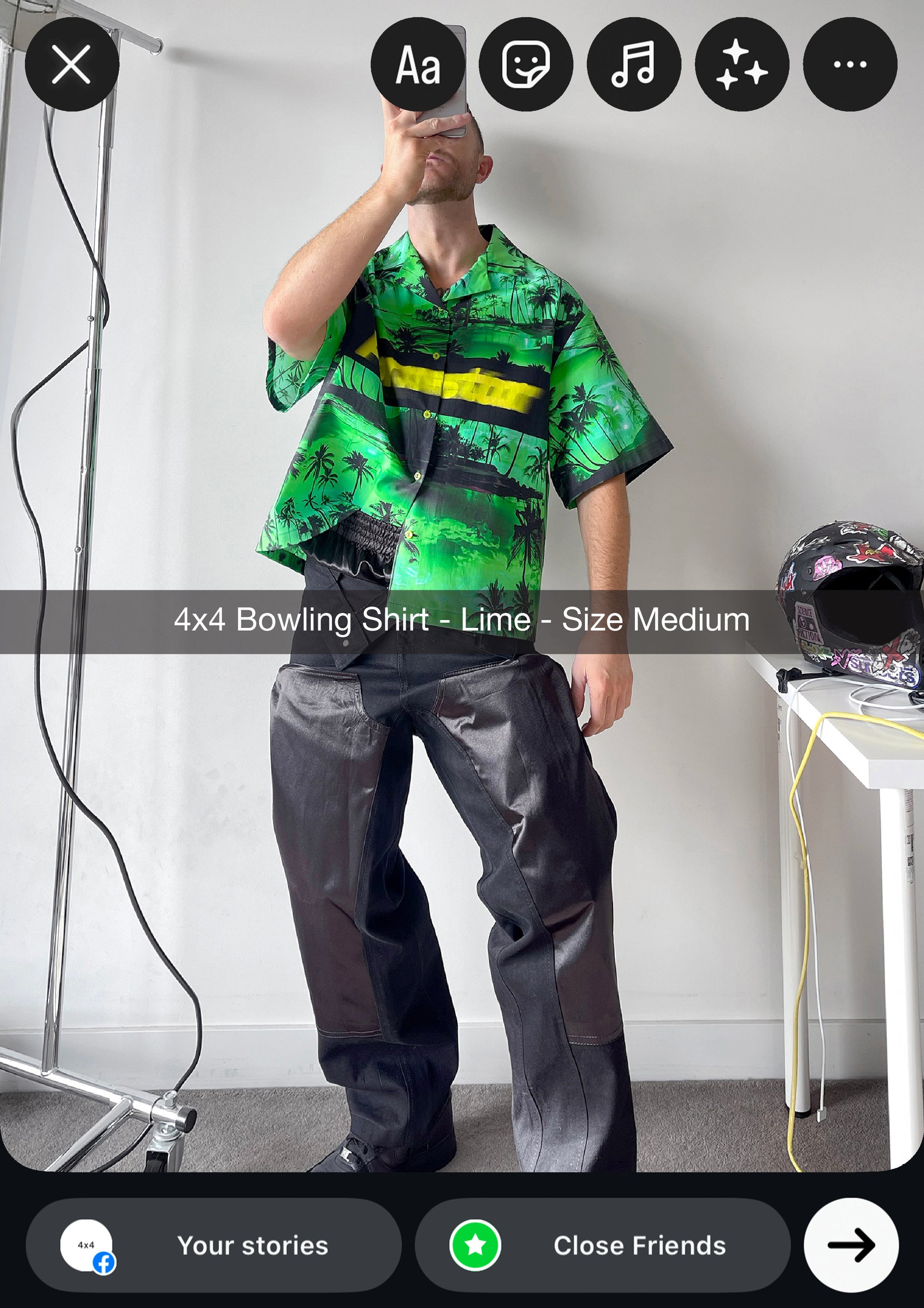 Person wearing a green and black patterned shirt with a yellow stripe, standing in a room.
