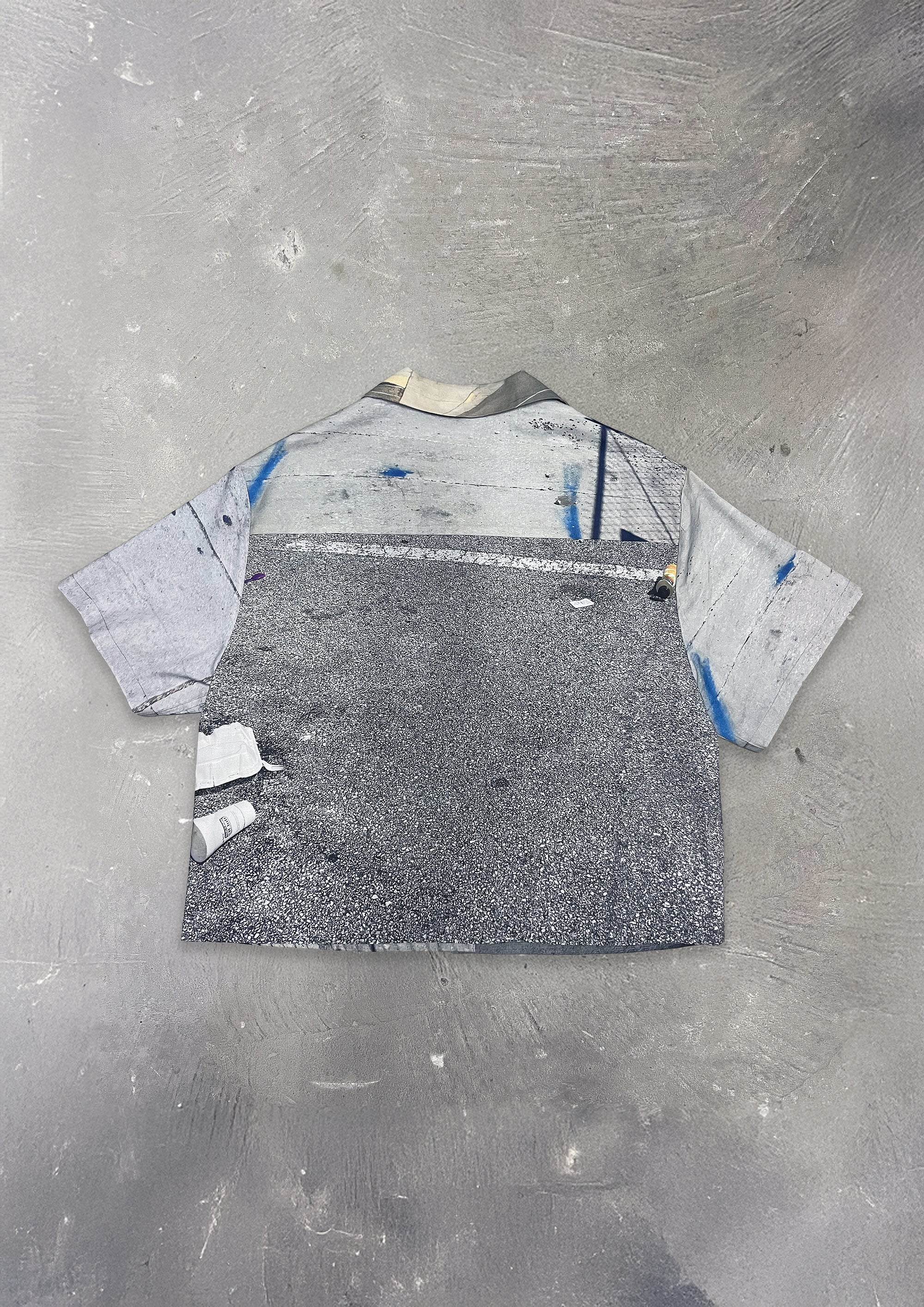 Gray t-shirt with abstract design on a textured gray surface