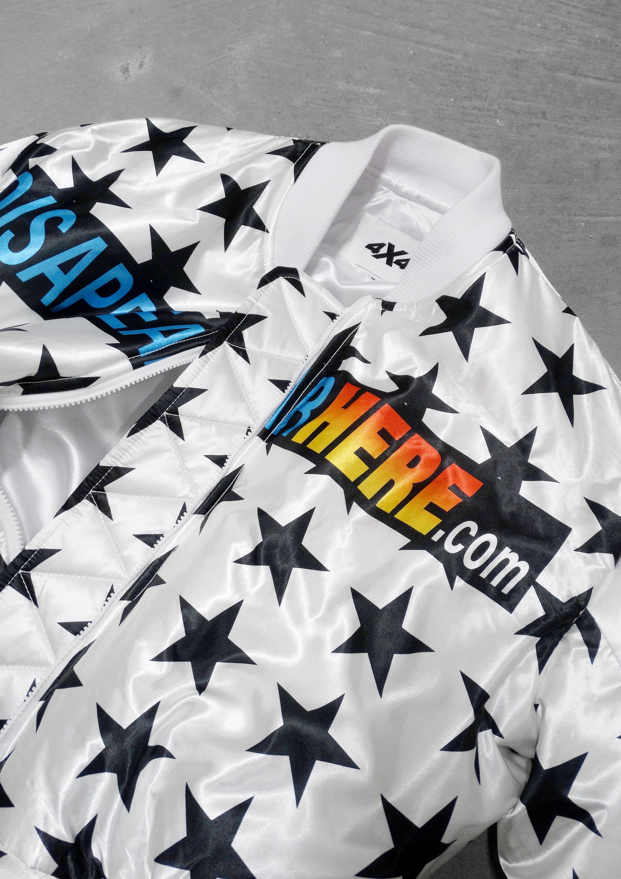 White jacket with black star pattern and colorful branding on a gray background