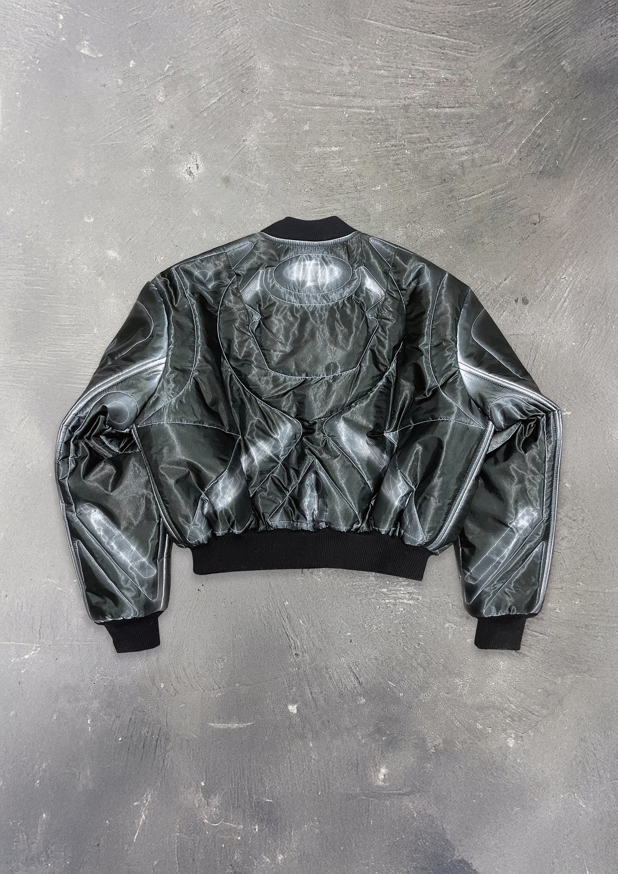 Silver reflective bomber jacket on a textured gray background