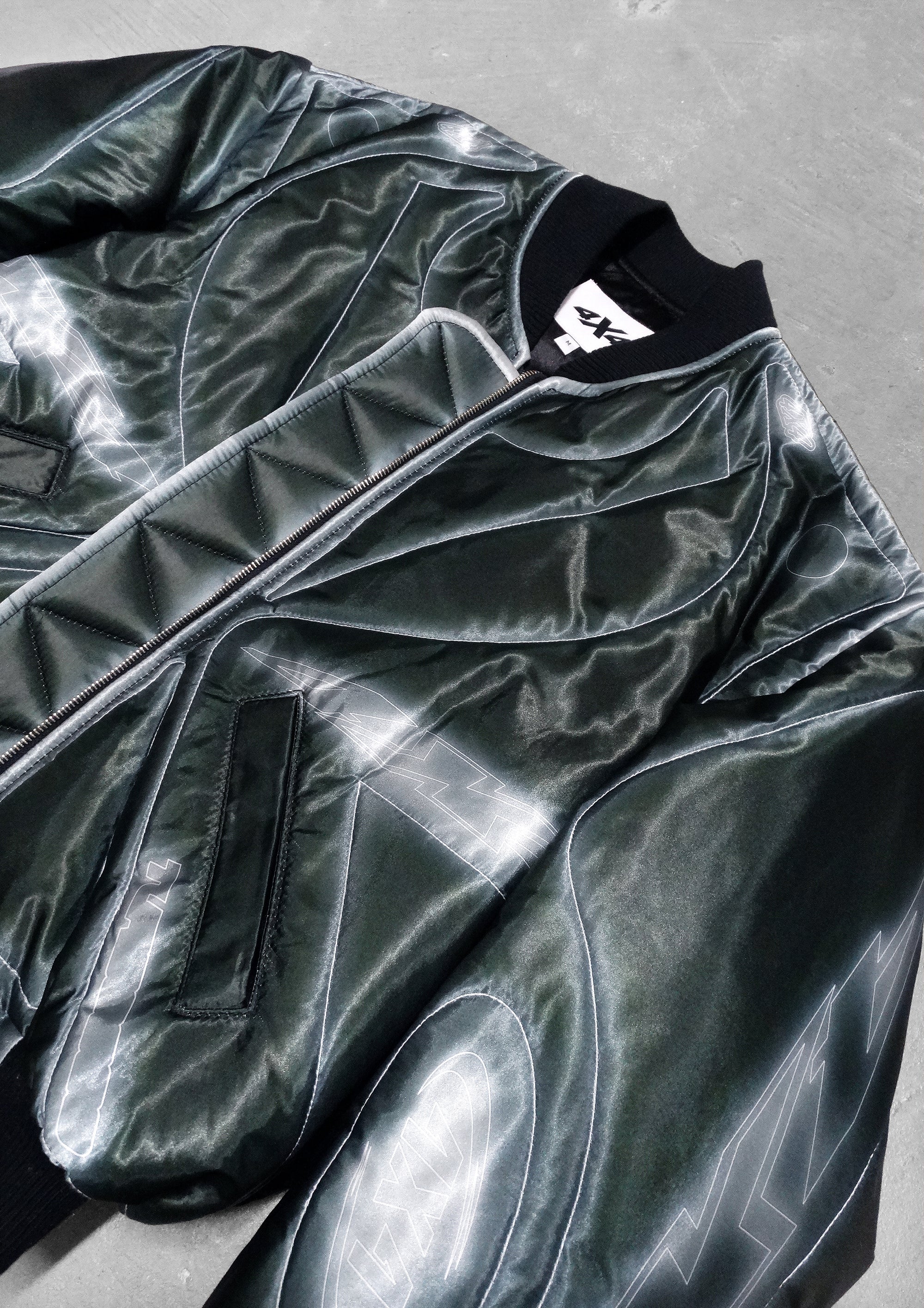 Shiny black jacket with a brand logo on a gray surface