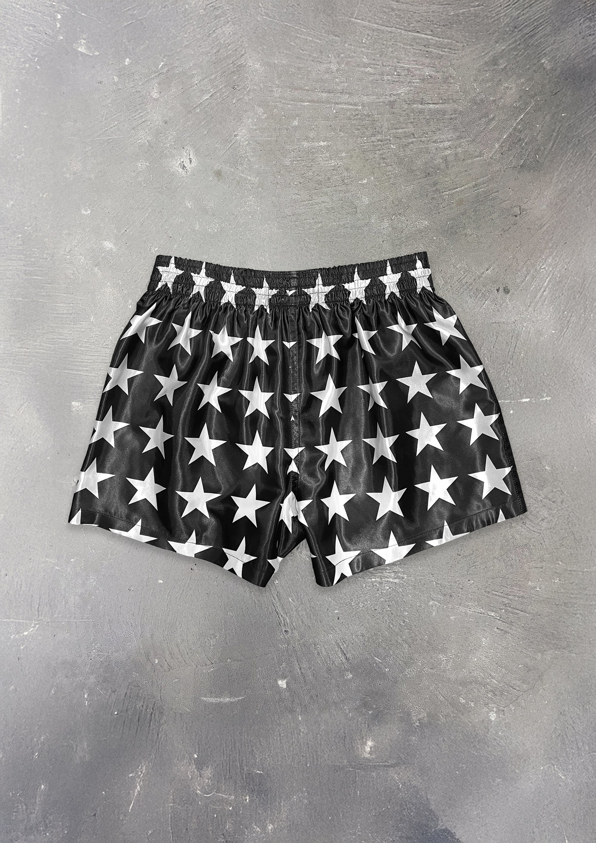 Black boxer briefs with white star pattern on a gray surface