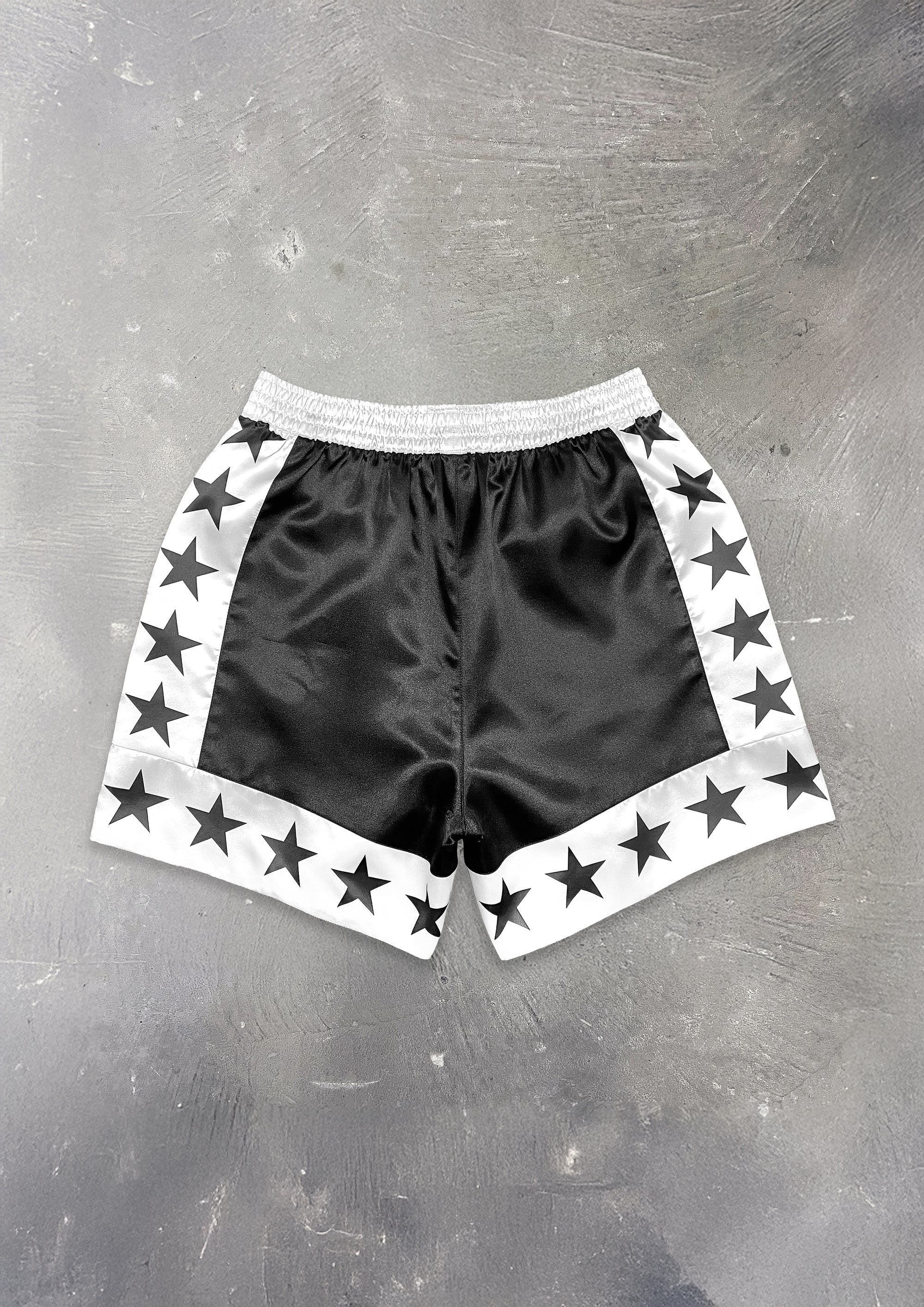 Black shorts with star patterns on a gray surface