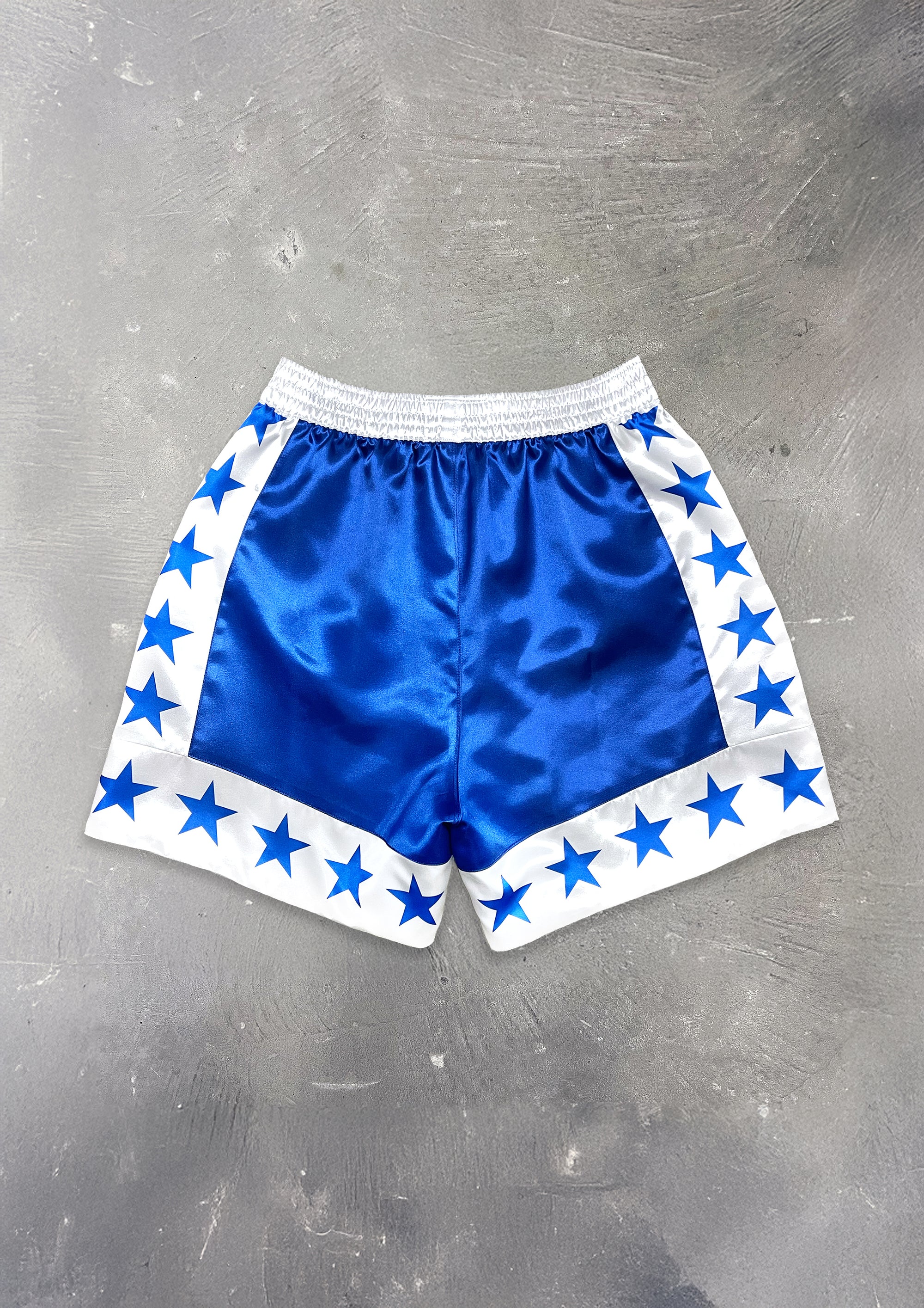 Blue shorts with star patterns on a gray surface