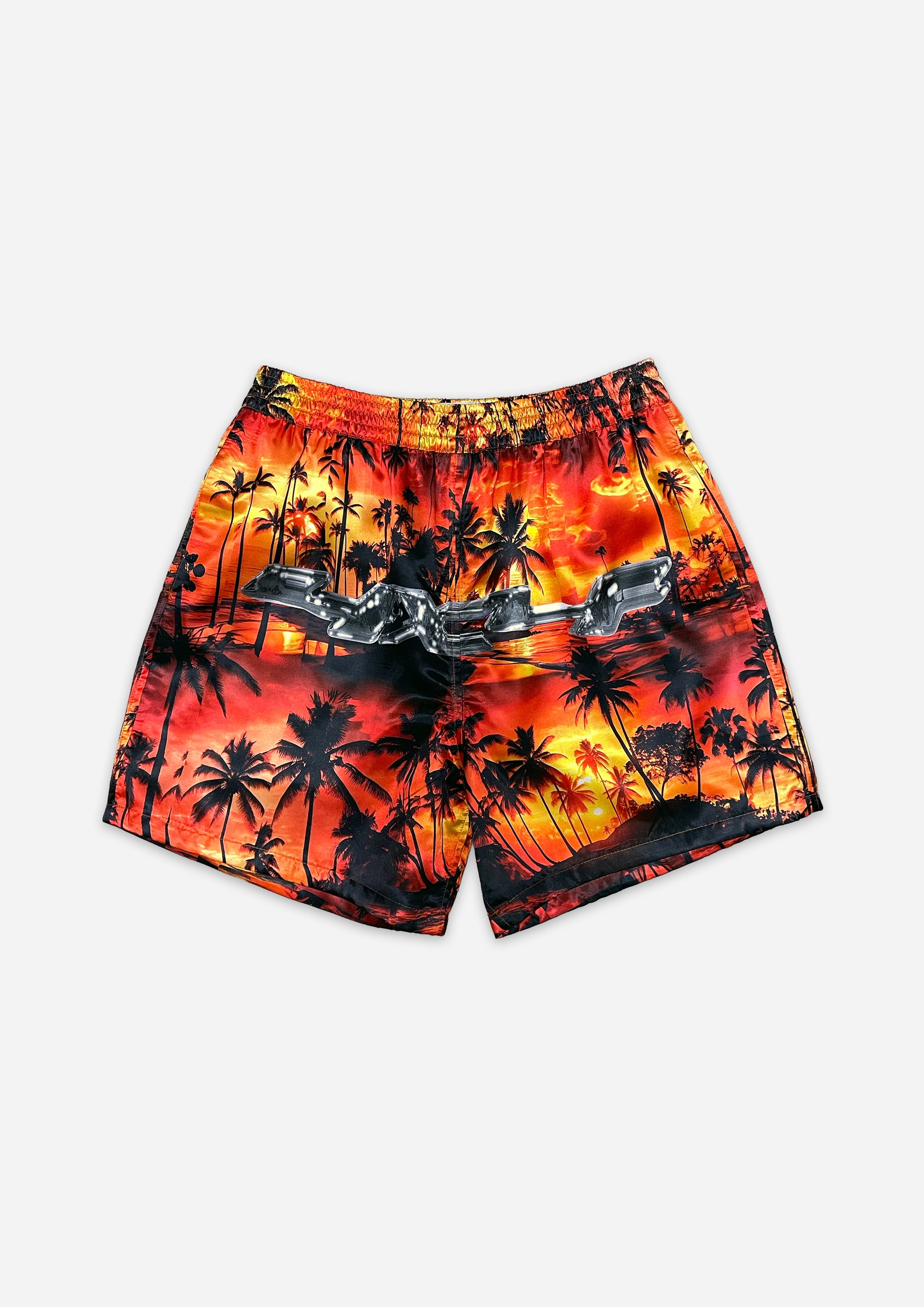 Beach shorts with palm tree and sunset design on a white background
