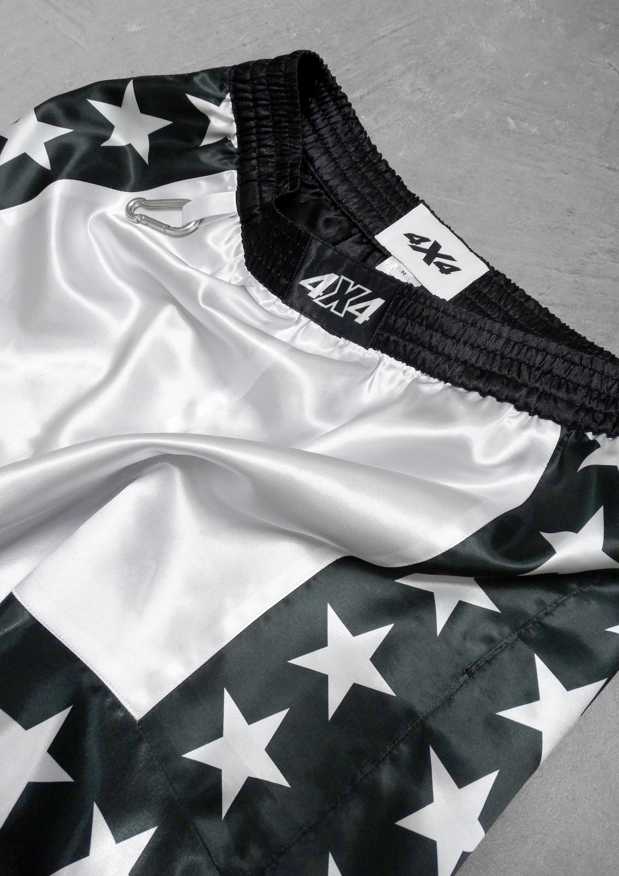 Black and white star-patterned shorts with a brand logo on a gray background
