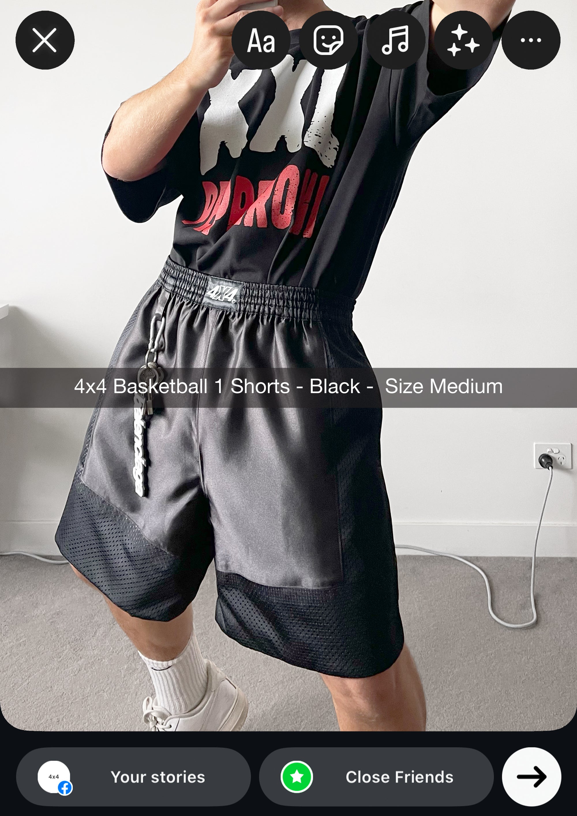 Person wearing black and gray basketball shorts with a brand logo, standing indoors.