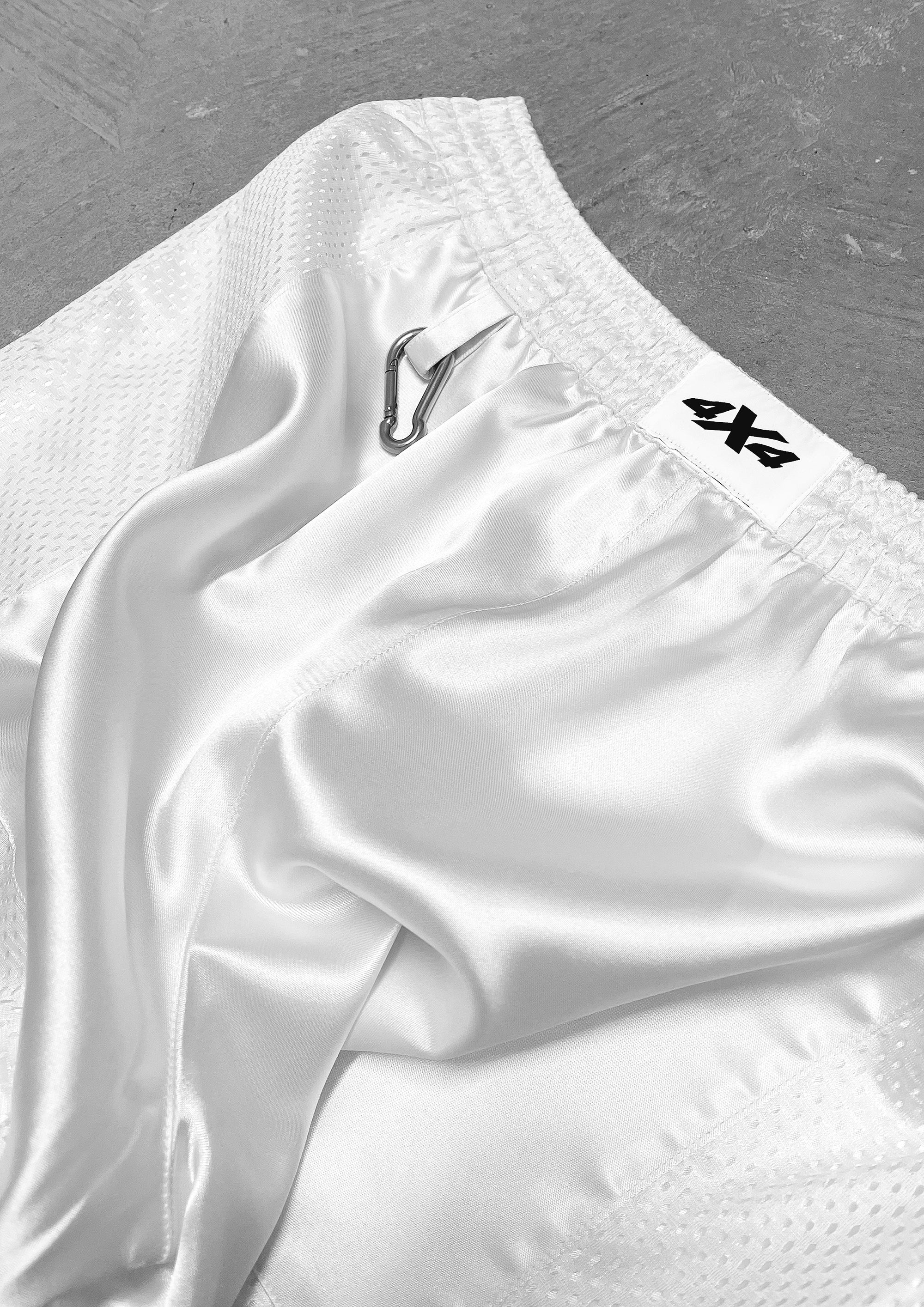 White shorts with a brand logo on a gray background