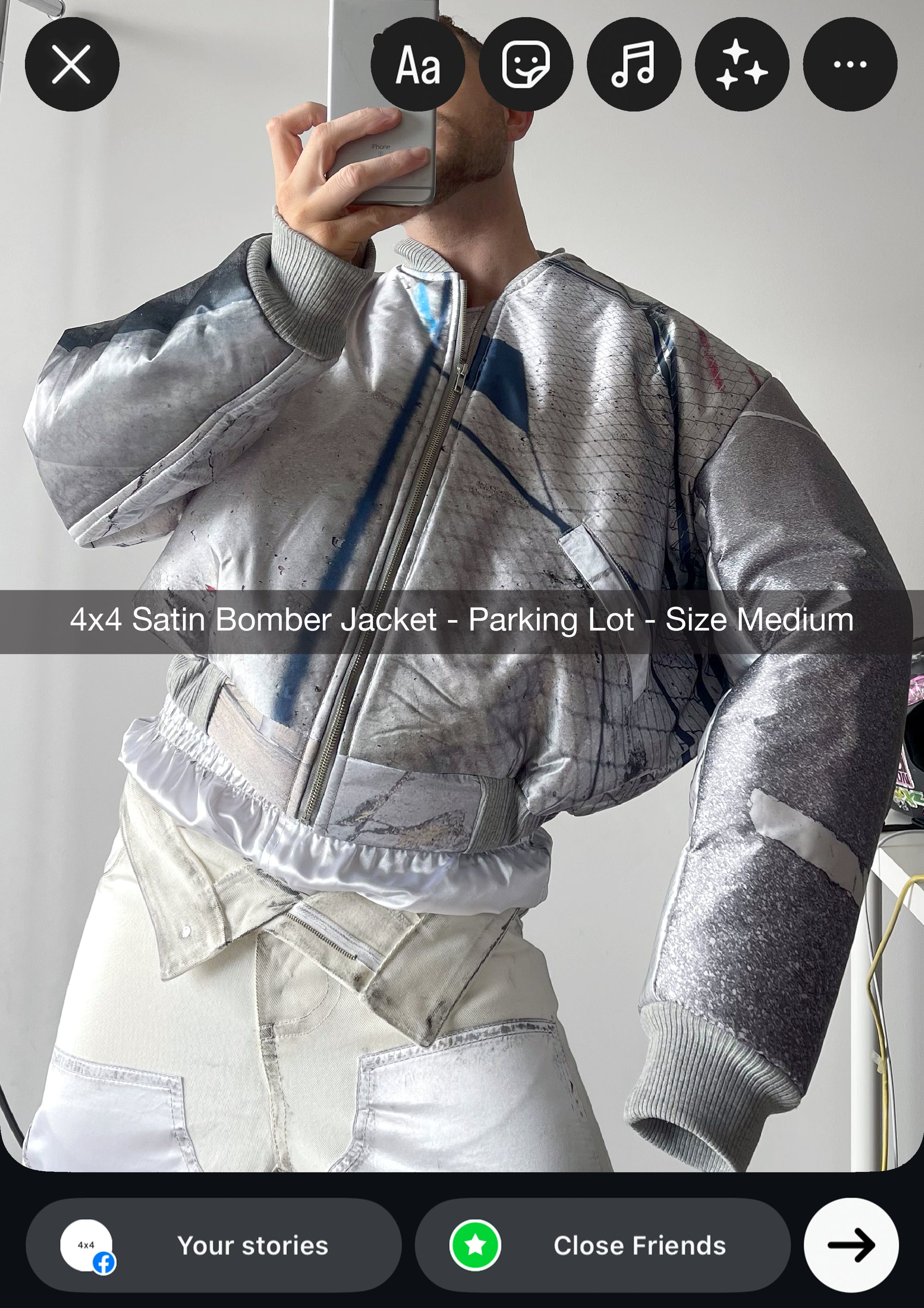 Person wearing a silver satin bomber jacket with text indicating size and color.