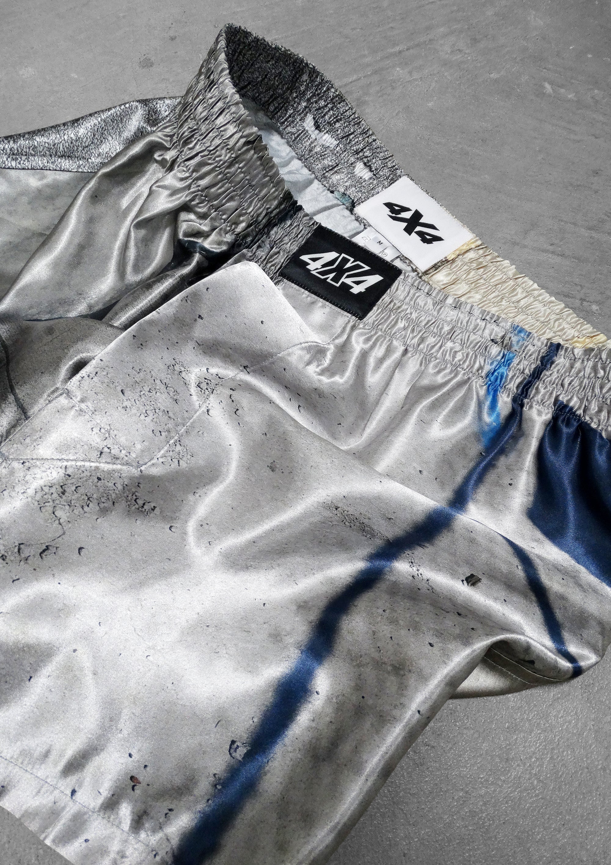 Silver jacket with a brand logo on a gray surface